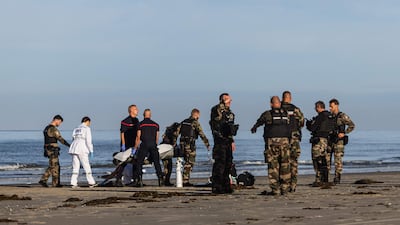 French firefighters and gendarmes carry the body of a man in a bag following an attempted migrant departure for a crossing of the English Channel, on the beach of Hardelot in Neufchatel-Hardelot, northern France. AFP