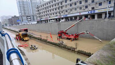 Rescuers use a pumping machine to clear out water from a flooded underpass.