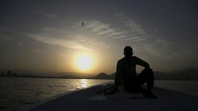 A fisherman looks toward the sunset as he and his crew fish near the Al Rughayalat Port. Silvia Razgova / The National