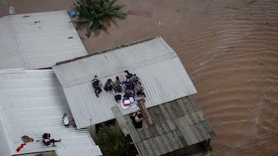 People wait to be rescued by a Brazilian Army helicopter during an operation to rescue people trapped in their homes due to a flood, in Canoas. EPA