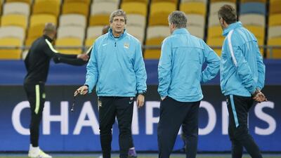 Manchester City manager Manuel Pellegrini talks to assistant managers Ruben Cousillas (R) and Brian Kidd during training. Action Images via Reuters / John Sibley