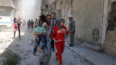 Syrians run for cover amid the rubble of destroyed buildings following a reported air strike on the rebel-held neighbourhood of Al Qatarji in Aleppo. Ameer Al Habli / AFP Photo