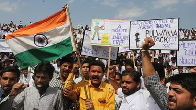 Indian college students and locals hold an Indian national flag and placards as they react after hearing news that the Indian Air Force carried out strikes across the Line of Control (LoC) near Pakistan. EPA