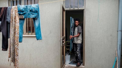 Eritrean artist Nebay Abraha, 23, exits his room and studio carrying a painting in Addis Ababa. AFP
