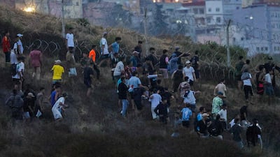 People gather on a hillside near Bab Sebta, on the border between Morocco and Spain. AFP
