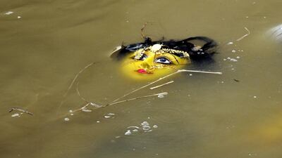 A clay idol of goddess Durga floats in a river following immersion at Agartala, India. Arindam Dey / AFP