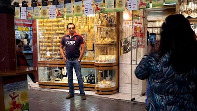 Nandita Sharma takes a photo of her husband Atul Sharma in front of Kanz Jewels at the Gold Souq in Deira. The couple are tourists in Dubai and are visiting from New Delhi. "Although the price difference in gold is minimal between here and India, at least???