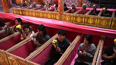 Buddhists pray in coffins during a resurrection ceremony, which symbolises their death and rebirth, at Wat Ta Kien temple in Nonthaburi, Thailand. AFP