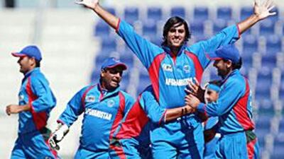 Afghanistan players celebrate taking a wicket in their victory over Scotland at Zayed Cricket Stadium yesterday. They take on the United States today.