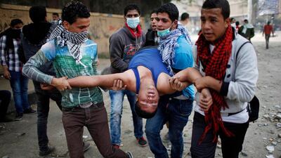 Anti-Morsi protesters carry a man affected by tear gas during clashes with riot police at Tahrir Square in Cairo November 27, 2012. Ahmed Jadallah / Reuters
