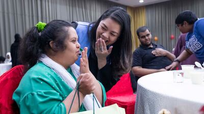A volunteer distributes gifts and socialises with children of determination at the iftar