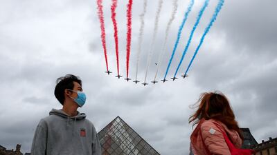 Spectators in Paris watch the air display above the Louvre in Paris.