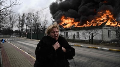 A house burning after being shelled in the city of Irpin, outside Kyiv. The conflict could reduce global GDP by 1% by 2023. AFP