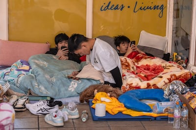 Displaced residents rest inside a shopping mall near the scene of the fire that swept through several apartment blocks at the Wang Fuk Court residential estate in Hong Kong's Tai Po district. AFP