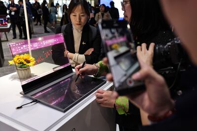 Attendees test a concept ThinkBook laptop computer featuring a transparent display at the Lenovo Group booth on the opening day of the Mobile World Congress in Barcelona. Bloomberg