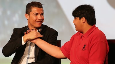 Real Madrid's Cristiano Ronaldo shakes hand with a handicapped young Emirati during the first session of the eighth Dubai International Sports Conference. Marwan Naamani / AFP