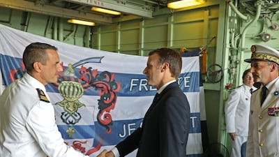 French president Emmanuel Macron is welcomed aboard French warship Jean-Bart at a naval base in Abu Dhabi on November 9, 2017. On the right stands French vice-admiral Didier Piaton. Ludovic Marin / AFP