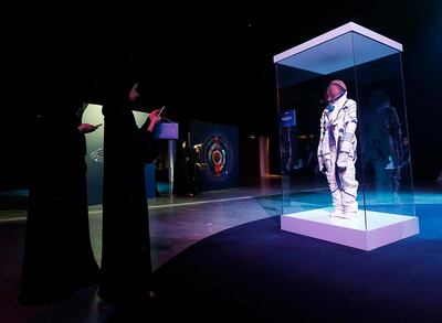 Visitors view a space suit on display at the Science Event 2019, as it was revealed that the wait for the first Emirati in space will go on a little longer. Satish Kumar/ For the National