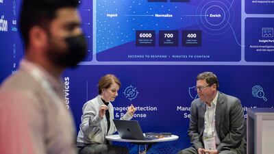 People discuss at a stand at Gisec.