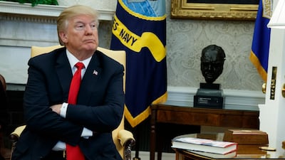 President Donald Trump listens during a meeting with North Korean defectors where he talked with reporters about allowing the release of a secret memo on the FBI's role in the Russia inquiry, in the Oval Office of the White House. Evan Vucci/ AP Photo