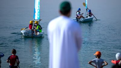 Parents and siblings cheer on the mini regatta from the sidelines.