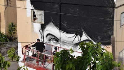 Hombre SUK's mural being worked on. Courtesy Baladk Project