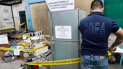 A member of the Philippine Drug Enforcement Agency (PDEA) puts caution tape around seized equipment for the manufacture of illegal drugs, before a destruction procedure in Valenzuela City, north of Manila, Philippines, on October 12, 2017. Rolex Dela Pena / EPA