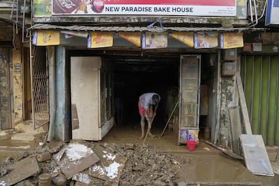 A man cleans up his shop after floods in Gelioya, Sri Lanka. AP