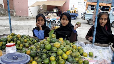 Female pupils buy fruit from a vendor during lunchtime break. Many girls were prevented from attending school in areas controlled by the Taliban