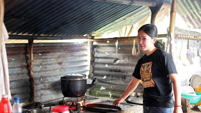 Aiza Tonida prepares lunch in a make-shift kitchen at their temporary shelter in Barangay Merin. (Joey Reyna for The National / April 9, 2014)