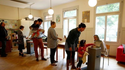 People cast their ballots in a school in Bern, Switzerland, June 5, 2016. Voters are deciding on whether to give every adult citizen a basic guaranteed monthly income of 2,500 Swiss francs. Ruben Sprich/Reuters