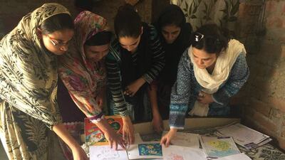 Women have their worked checked in a free literacy class in Uttar Pradesh. Courtesy Kidwai family