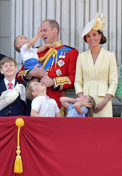 The family watch the Red Arrows and more planes during the flypast. AFP