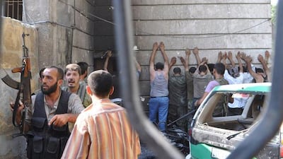 Free Syria Army opposition fighters guard a group of detained policemen after overrunning and burning down the police station in the Shaar district of the city. Pierre Torres / AFP Photo