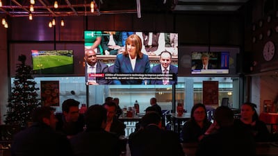 The Chancellor appears on a TV screen in a restaurant in the financial district of Canary Wharf. Reuters