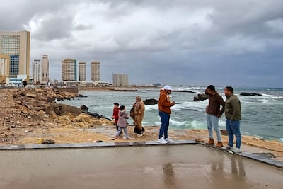 People gather along the promenade on a rainy day in Libya's capital Tripoli. Libya's economy is estimated to have grown by 13.3 per cent last year. AFP