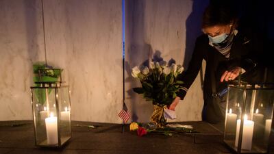 A flight attendant reads a card with flowers at the Wall of Names at the Flight 93 National Monument during the Luminaria Ceremony in Shanksville, Pennsylvania. AFP