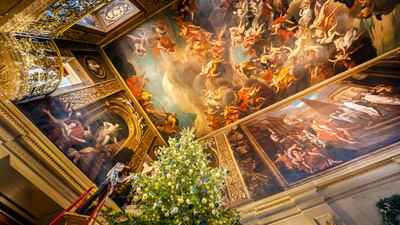 Olivia Housley puts the finishing touches to a Christmas tree in the Painted Hall at Chatsworth House in England. PA