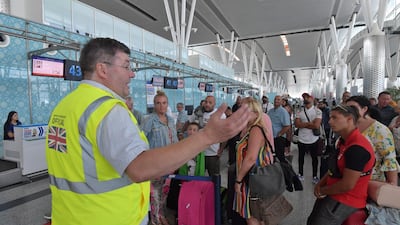A British government official speaks to tourists, flying with Thomas Cook, as they queue at the Enfidha International airport, on the outskirts of Sousse south of the capital Tunis. AFP