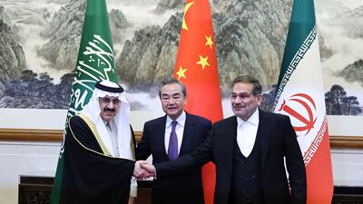 Ali Shamkhani, the secretary of Iran's Supreme National Security Council, right, shakes hands with Saudi national security adviser Musaad bin Mohammed Al Aiban, as Wang Yi, China's most senior diplomat, looks on, in Beijing, on March 11. Reuters