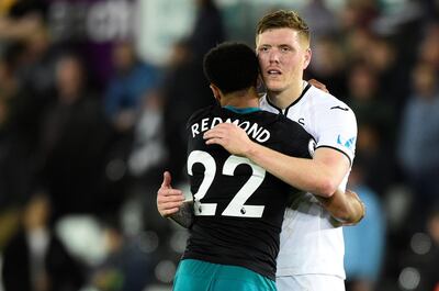 Swansea City's Alfie Mawson hugs Southampton's Nathan Redmond after Southampton won 1-0 at the Liberty Stadium on Tuesday to virtually send Swansea down. Rebecca Naden / Reuters