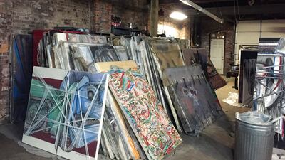 Paintings by Francis Hines sit wrapped in plastic in a barn. AP