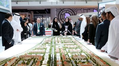 People gather around the Manazel display during Cityscape in Abu Dhabi. The listings website Dubizzle said there had been a steep rise in demand for emerging, inland communities in Abu Dhabi and Dubai. Christopher Pike / The National