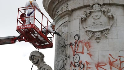 Municipality workers remove graffiti from the Republique Statue in Paris – which became the focal point of mourning following attacks in the French capital – on August 8, 2016. Michel Euler/AP Photo