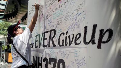 In Kuala Lumpur, a relative writes a on a message board during a memorial event ‘MH370 Day of Remembrance’ at The Square of Publika. Anthony Kwan / Getty Images