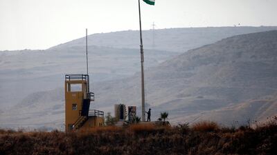 A Jordanian soldier pulls a Jordanian national flag in an outpost at the border area between Israel and Jordan at Naharayim, as seen from the Israeli side. Reuters