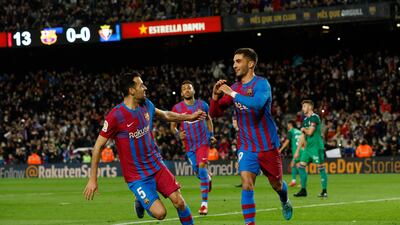 Ferran Torres celebrates with Sergio Busquets after scoring Barcelona's first goal against Osasuna. Reuters