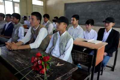 A bouquet of flowers is placed as a tribute on the desk of 19-year-old Parviz Noori who was killed in front of his school, in Kabul, Afghanistan, on April 23, 2022. AP Photo