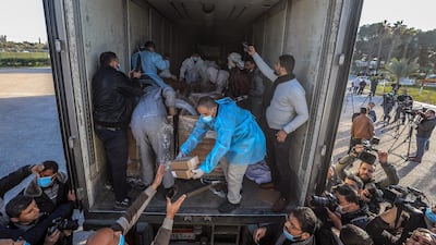 Palestinian health care workers offload cases of vaccine vials donated by the UAE after a shipment crossed through the Rafah crossing, on Gaza’s border with Egypt. EPA