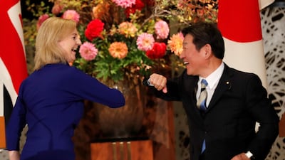 Britain's international trade secretary Liz Truss and Japan’s Foreign Minister Toshimitsu Motegi bump elbows during their news conference following a signing ceremony of the UK-Japan trade agreement in Tokyo on Friday. Reuters